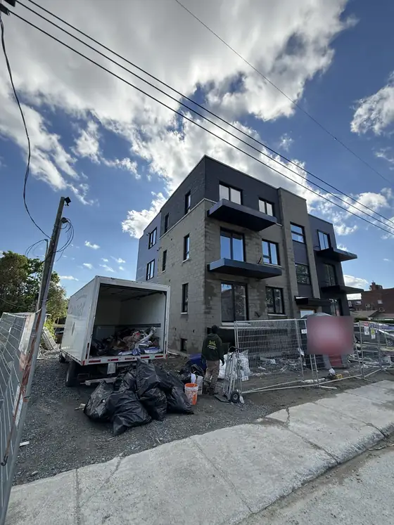 Intervention sur chantier à Laval : camion et employé ByeByeJunk avec des sacs de débris de construction